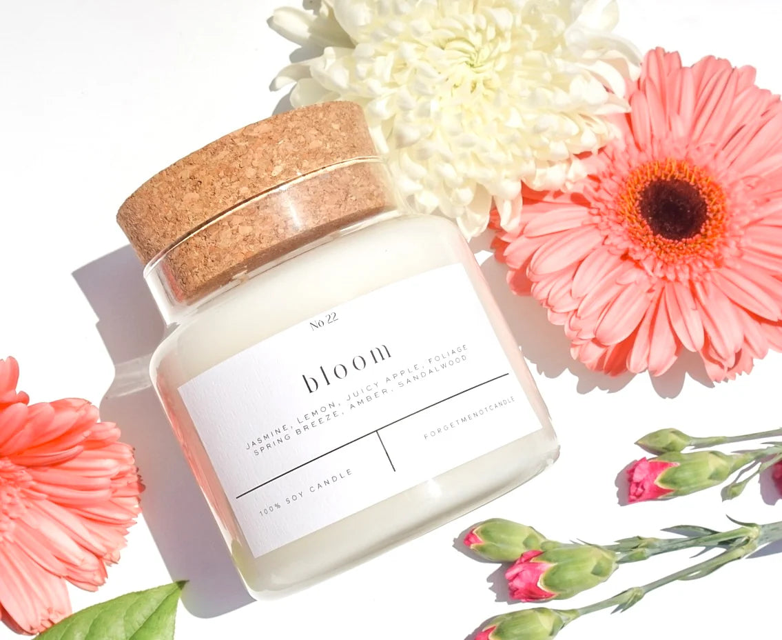 Bloom Candle 22oz in a glass jar with notes of jasmine, lemon, and fresh foliage.